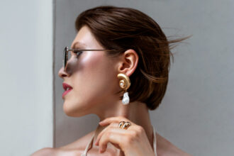 mulher rica com acessorios luxuosos oculos de grife e brincos dourados
