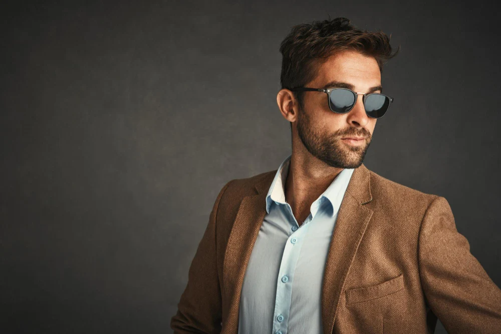 Homem usando óculos de sol que mais combina com seu formato de rosto e roupas sociais