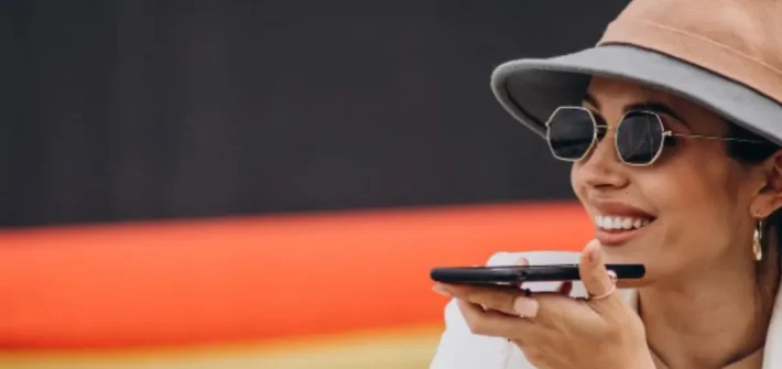 mulher de chapeu com óculos escuros sabendo como cuidar dos óculos durante a sua viagem