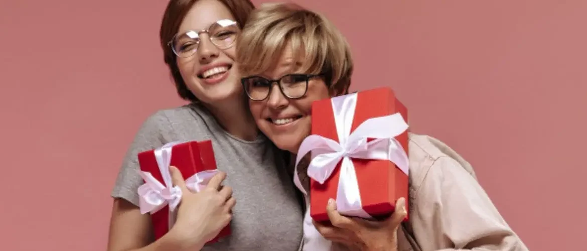 Mãe e filha felizes se abraçando com presente na mão