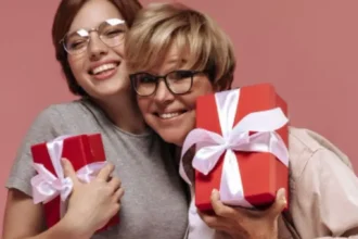 Mãe e filha felizes se abraçando com presente na mão
