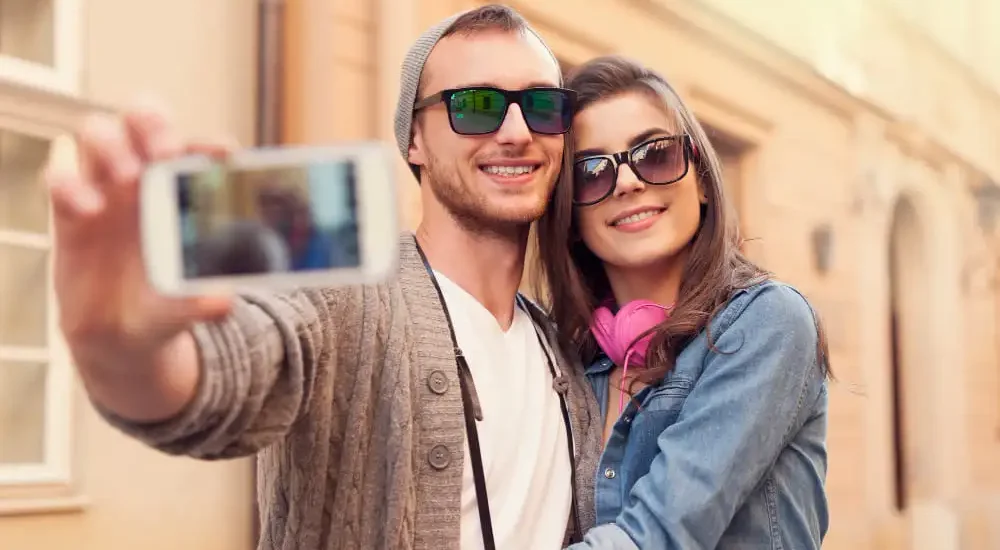 Casal tirando uma selfie enquanto usam óculos de sol