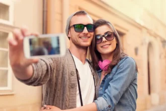 Casal tirando uma selfie enquanto usam óculos de sol