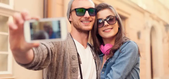 Casal tirando uma selfie enquanto usam óculos de sol