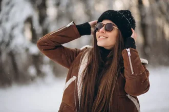 Mulher sorridente usando óculos escuro na neve