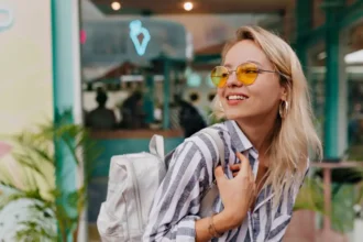 Mulher posando para foto feliz com seu óculos de sol