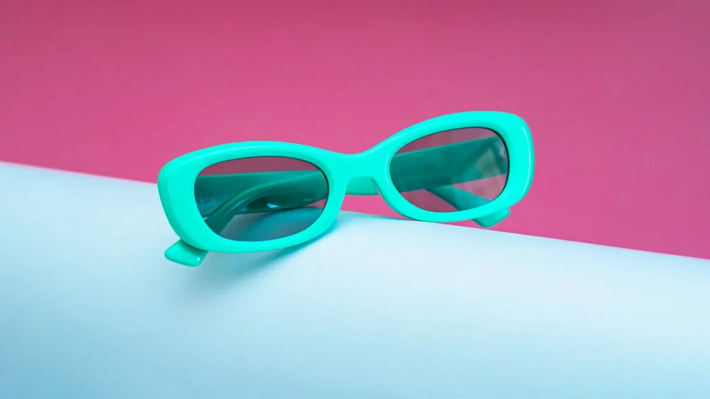 Óculos de sol tendência verão 2026 com tons vibrantes de turquesa em fundo azul claro e rosa