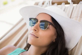 Mulher deitada em rede com óculos de sol e acessórios de verão