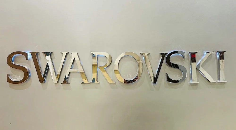 Placa com nome da loja de óculos Swarovski em material espelhado