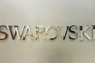 Placa com nome da loja de óculos Swarovski em material espelhado