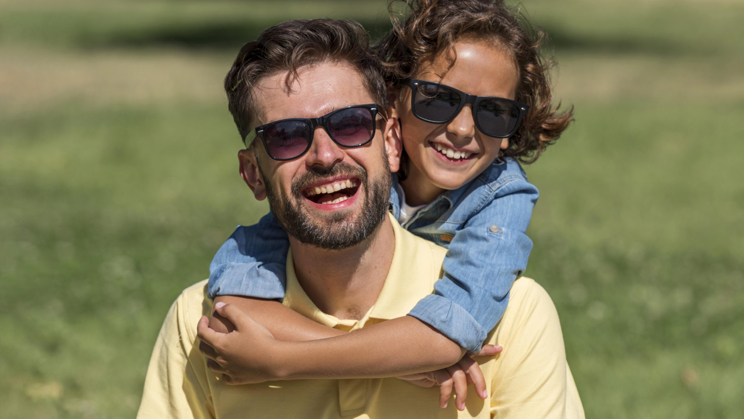 pai e fliho felizes usando oculos de sol combinando