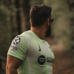Homem branco com uniforme de time de futebol usando óculos dos jogadores de futebol