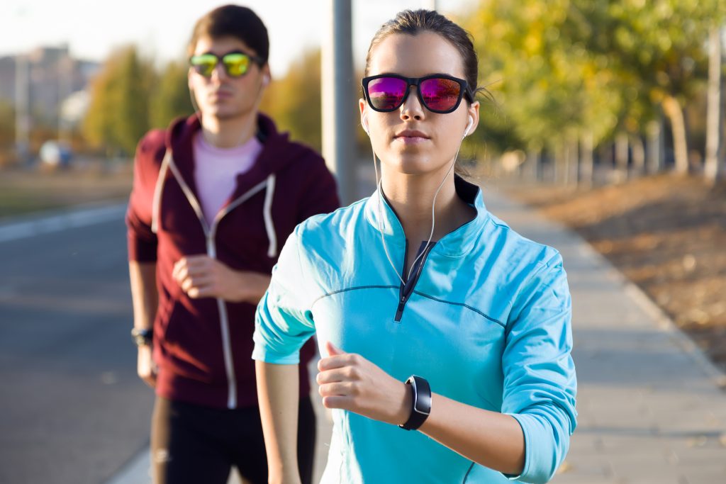 casal praticando corrida com oculos de sol estiloso