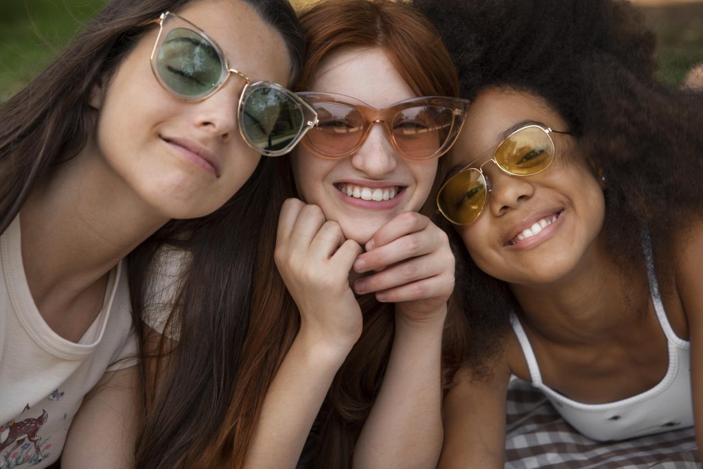 tres amigas usando oculos de sol de uma coleção de oculos
